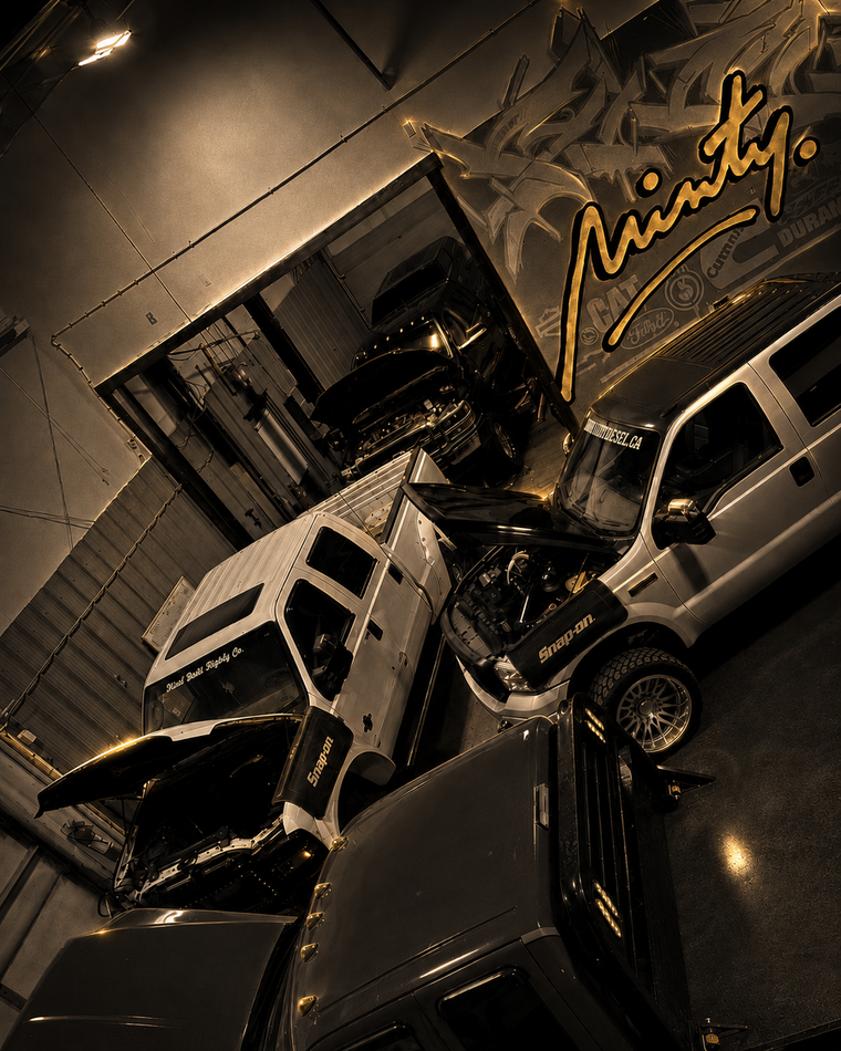 Minty Diesel workshop with custom diesel trucks and gold mural